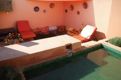 a living room with chairs and a pool of water at Riad Sassa Finda in Marrakech