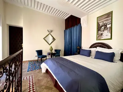 a bedroom with a large bed and a balcony at Riad Sassa Finda in Marrakech
