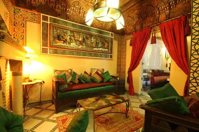 a living room with a green couch and red curtains at Riad Esmeralda in Marrakech