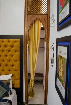 a mirror on a wall next to a bed at Riad Esmeralda in Marrakech