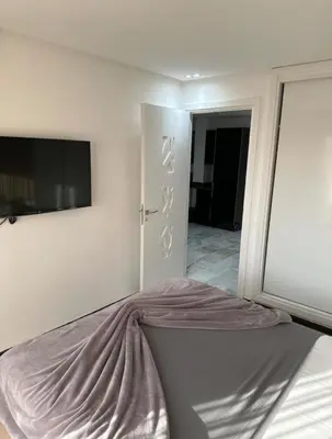 a bedroom with a bed and a tv on the wall at Super appartement au cœur de Marrakech in Marrakech