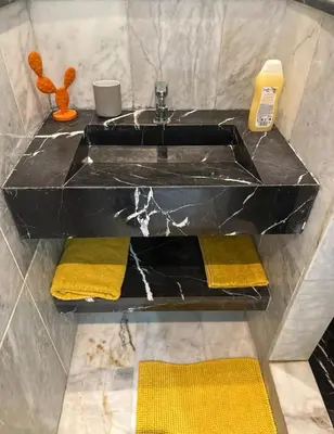 a bathroom with a black sink and yellow towels at Super appartement au cœur de Marrakech in Marrakech