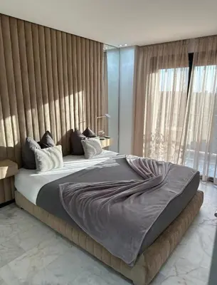 a bedroom with a large bed with a large window at Super appartement au cœur de Marrakech in Marrakech