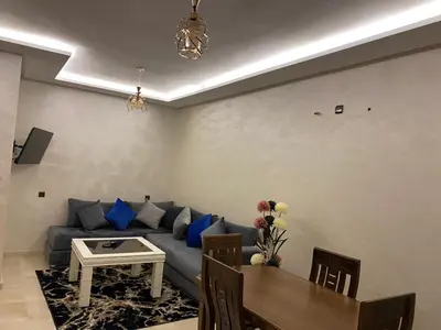 a living room with a blue couch and a table at Appartement de luxe Marrakech Gueliz in Marrakech