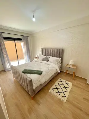 a bedroom with a large bed and a wooden floor at Cozy Apartment in the City Center - 100% Equipped in Marrakech