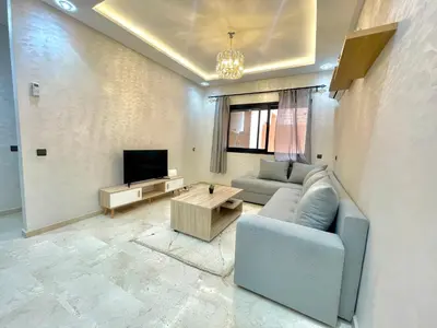 a living room with a blue couch and a tv at Cozy Apartment in the City Center - 100% Equipped in Marrakech