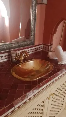 a sink in a bathroom with a mirror at Riad Le Manzil Beldi in Marrakech