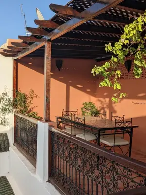 a patio with a table and chairs on a balcony at Riad Le Manzil Beldi in Marrakech