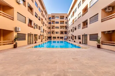 an empty swimming pool in an apartment building at Chic & Cosy Appart au Centre Ville - 100 % Équipé in Marrakech