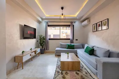 a living room with a couch and a tv at Chic & Cosy Appart au Centre Ville - 100 % Équipé in Marrakech