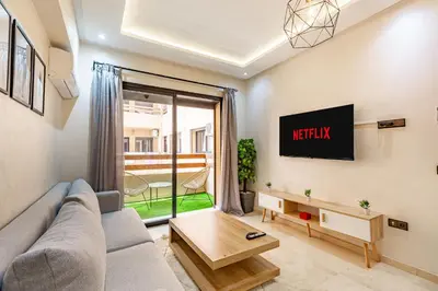a living room with a couch and a tv at Jolie & Luxueux Appart a Gueliz - 100% Équipé in Marrakech