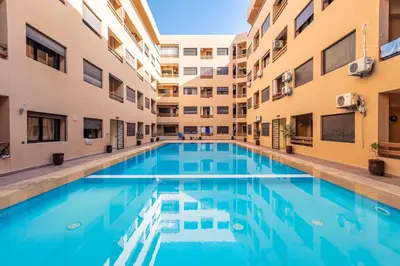 a swimming pool in an apartment complex with buildings at Jolie & Luxueux Appart a Gueliz - 100% Équipé in Marrakech