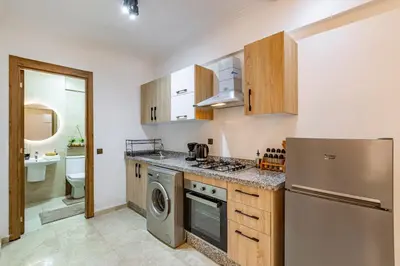 a kitchen with a refrigerator and a washer and dryer at Jolie & Luxueux Appart a Gueliz - 100% Équipé in Marrakech