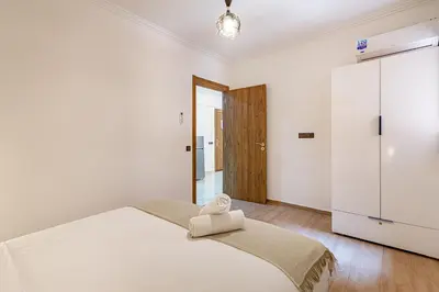 a white bedroom with a bed and a refrigerator at Jolie & Luxueux Appart a Gueliz - 100% Équipé in Marrakech