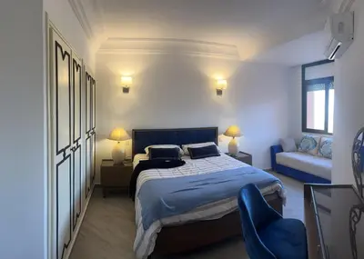 a bedroom with a bed and a couch at Appartment le bleu in Marrakech