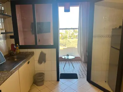 a kitchen with a shower and a sink and a table at Appartment le bleu in Marrakech