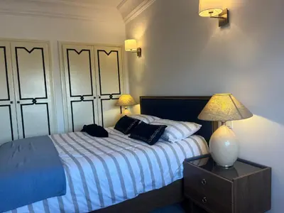 a bedroom with a bed and a lamp on a night stand at Appartment le bleu in Marrakech