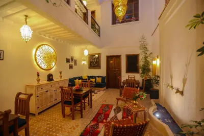 a living room with a couch and a table and chairs at Riad Beni Sidel in Marrakech