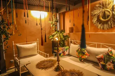 a room with two chairs and a table with pillows at Riad Beni Sidel in Marrakech