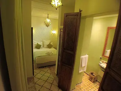 a bedroom with a bed and a large mirror at Riad Beni Sidel in Marrakech