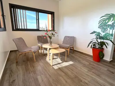 a waiting room with chairs and a table with flowers at Belle et spacieuse villa au Golf Amelkis Marrakech in Marrakech