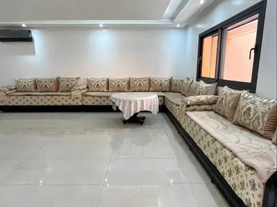 a living room with a couch and a table at Belle et spacieuse villa au Golf Amelkis Marrakech in Marrakech