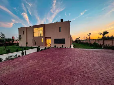 a house with a brick driveway in front of it at Villa 7palms in Marrakech