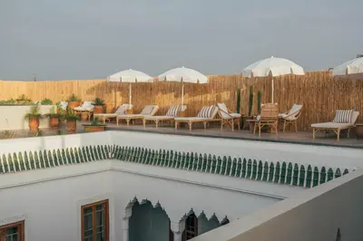 a balcony of a hotel with chairs and umbrellas at Riad no37 in Marrakech