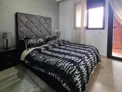 a black and white bed in a bedroom with a window at appartement in Marrakech