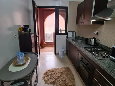 a kitchen with a counter top and a table with a sink at appartement in Marrakech