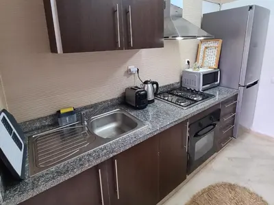 a small kitchen with a sink and a microwave at appartement in Marrakech
