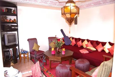 a living room with a red couch and a table at Chez Peyo in Marrakech