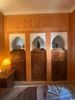 a room with a wall with three arched windows at Riad Dar Teranga Hotel & Spa in Marrakech