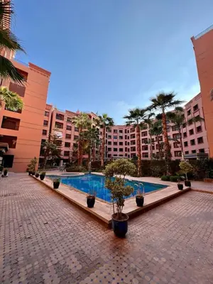 a courtyard with a swimming pool in a large building at Appartement chambre salon a l'hivernage 9 in Marrakech