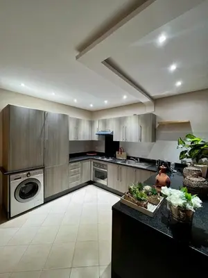 a large kitchen with a stove and a dishwasher at Appartement chambre salon a l'hivernage 9 in Marrakech