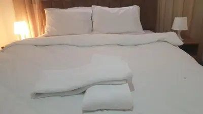 a white bed with white sheets and pillows at Apparemment wafaa in Marrakech