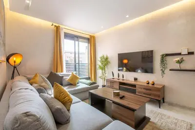 a living room with a couch and a tv at New ! Stunning and Comfortable apartement in Marrakech