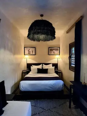 a bedroom with a large bed and a chandelier at Riad Casa Felicità & SPA in Marrakech
