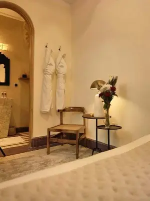 a bedroom with a mirror and a chair and a table at Riad Casa Felicità & SPA in Marrakech