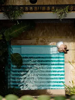 a person laying on the side of a swimming pool at Riad Casa Felicità & SPA in Marrakech