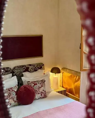 a bedroom with a bed with pillows and a largeboard on the wall at Riad Casa Felicità & SPA in Marrakech