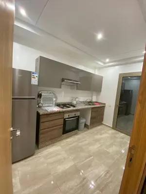 a kitchen with a stove and a refrigerator at Appartement a loué pour les familles in Marrakech