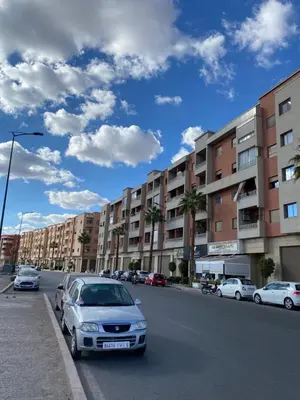 a car parked on the side of a street with buildings at Appartement a loué pour les familles in Marrakech