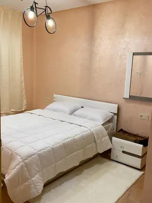 a bedroom with a large white bed and a mirror at Appartement a loué pour les familles in Marrakech