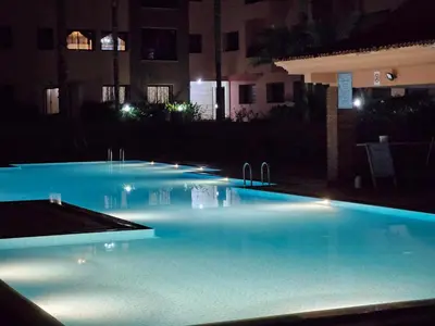 a swimming pool at night with blue water at Luxueux appartement Marrakech au cœur de l hivernage in Marrakech