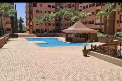 a swimming pool with a gazebo next to a building at Luxueux appartement Marrakech au cœur de l hivernage in Marrakech
