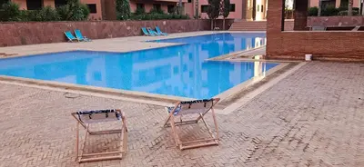 two chairs sitting next to a swimming pool at Luxueux appartement Marrakech au cœur de l hivernage in Marrakech