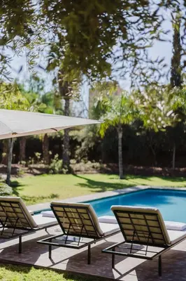 a group of chairs sitting next to a swimming pool at Villa de luxe Sahara in Marrakech