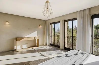a bedroom with a bed and a fireplace and windows at Villa de luxe Sahara in Marrakech