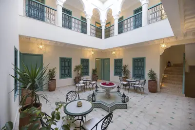 a large room with tables and chairs and stairs at Riad l'Esprit des Patios & Spa in Marrakech